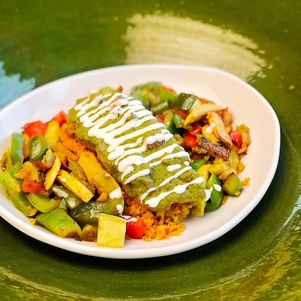 Señor Tomas' green enchilada drizzled with crema, served with Mexican rice and sautéed vegetables.