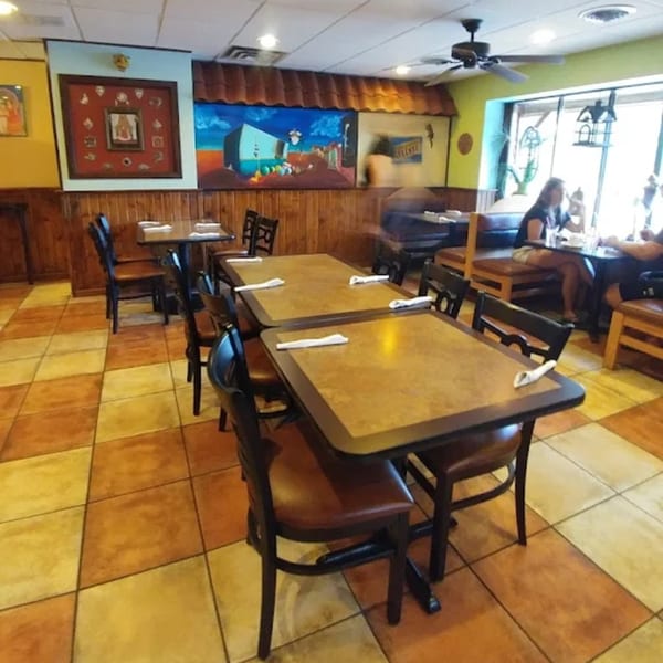 Interior of Señor Tomas Restaurant with empty tables, checkered floor, and Mexican-themed wall art.