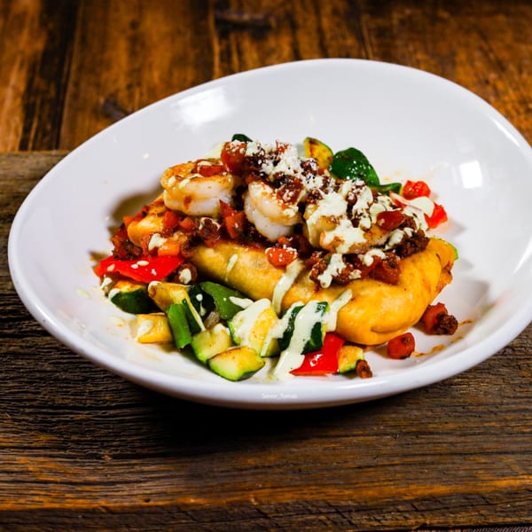 Señor Tomas' Mexican dish with shrimp, vegetables, and sauce on a white plate.